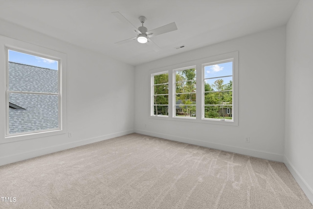 carpeted spare room with a healthy amount of sunlight and ceiling fan