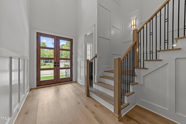 entrance foyer featuring a high ceiling, light hardwood / wood-style floors, and french doors