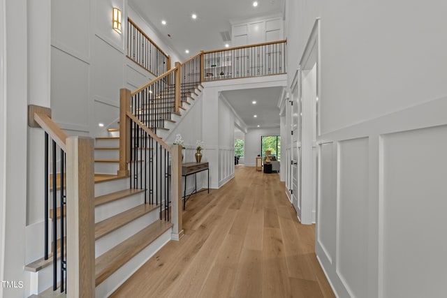 foyer with a towering ceiling and light hardwood / wood-style flooring