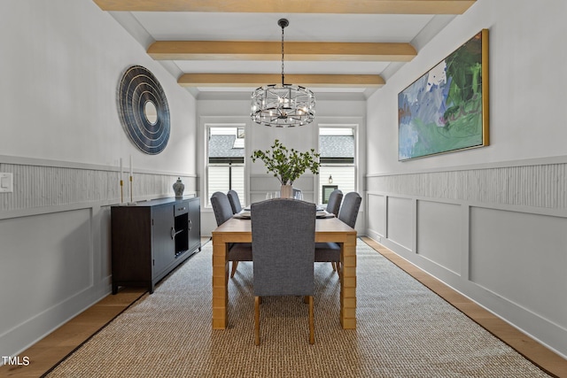 dining area featuring a notable chandelier, light hardwood / wood-style flooring, and beam ceiling