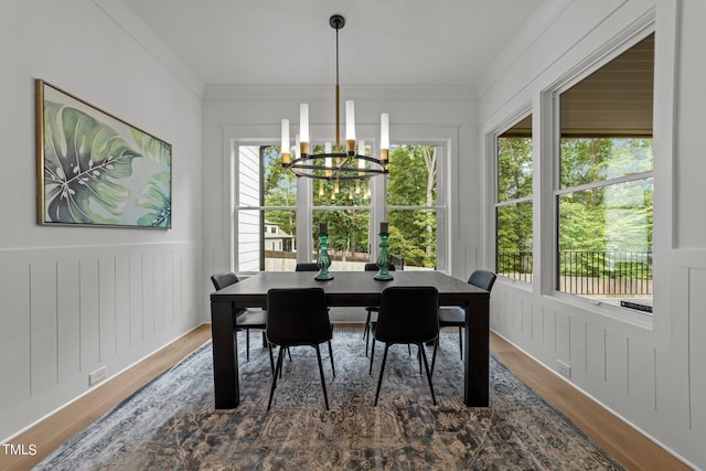 dining space with ornamental molding, a chandelier, and hardwood / wood-style flooring