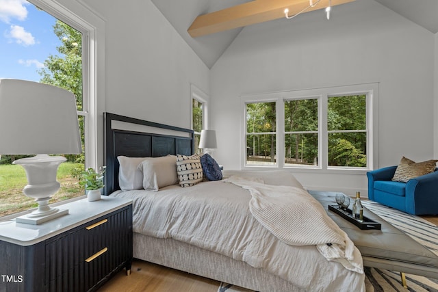 bedroom featuring hardwood / wood-style floors, beamed ceiling, and high vaulted ceiling