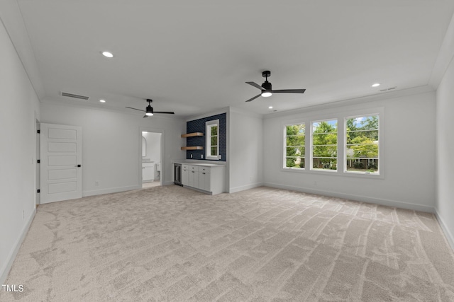 unfurnished living room with ceiling fan, light colored carpet, and crown molding