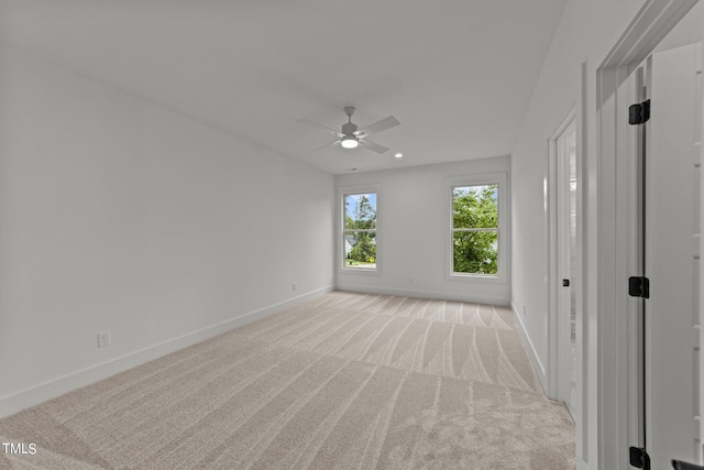 empty room featuring ceiling fan and light colored carpet