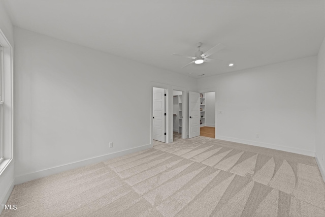 unfurnished room with ceiling fan and light colored carpet