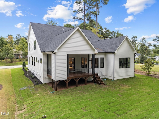 rear view of property with central AC unit and a yard