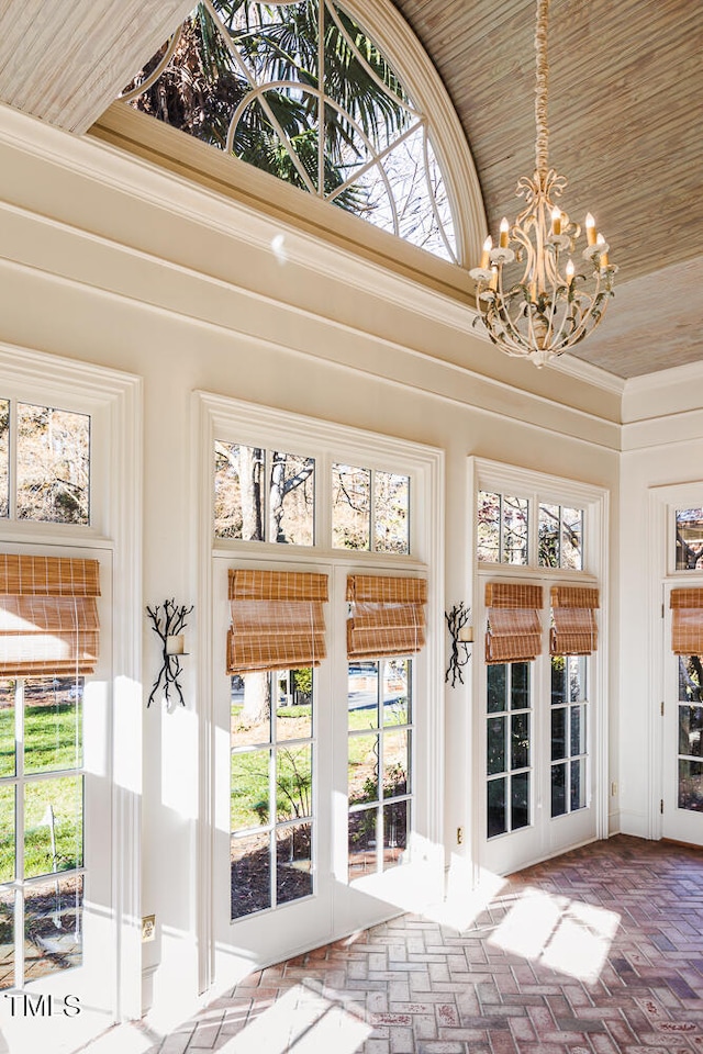 doorway with a notable chandelier, french doors, wooden ceiling, and a towering ceiling