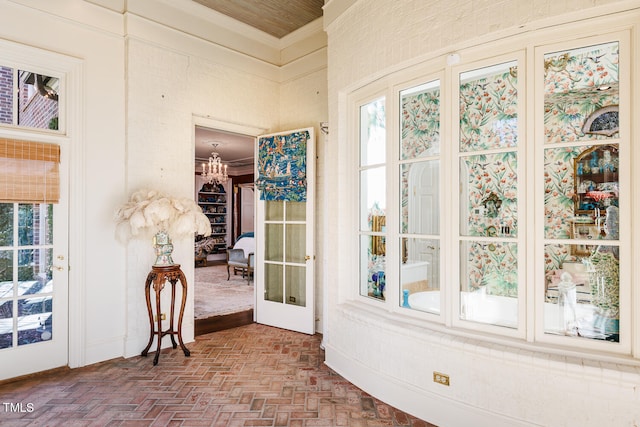 sunroom featuring french doors and a chandelier