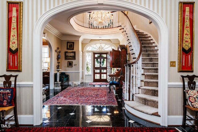 foyer entrance with crown molding, tile floors, french doors, and an inviting chandelier