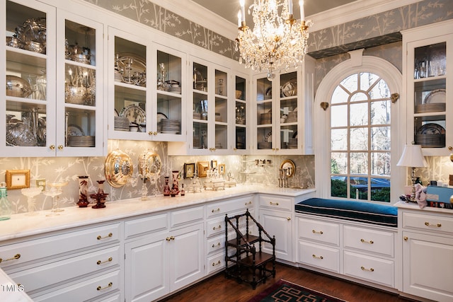 kitchen with hanging light fixtures, tasteful backsplash, white cabinetry, a chandelier, and dark hardwood / wood-style floors