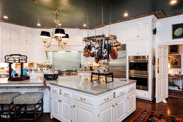 kitchen featuring white cabinets, appliances with stainless steel finishes, dark hardwood / wood-style flooring, and light stone countertops