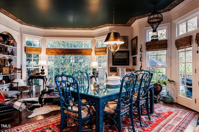 dining room with a notable chandelier, ornamental molding, plenty of natural light, and dark hardwood / wood-style floors