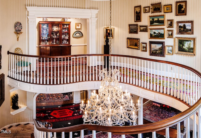 stairway with a high ceiling and an inviting chandelier