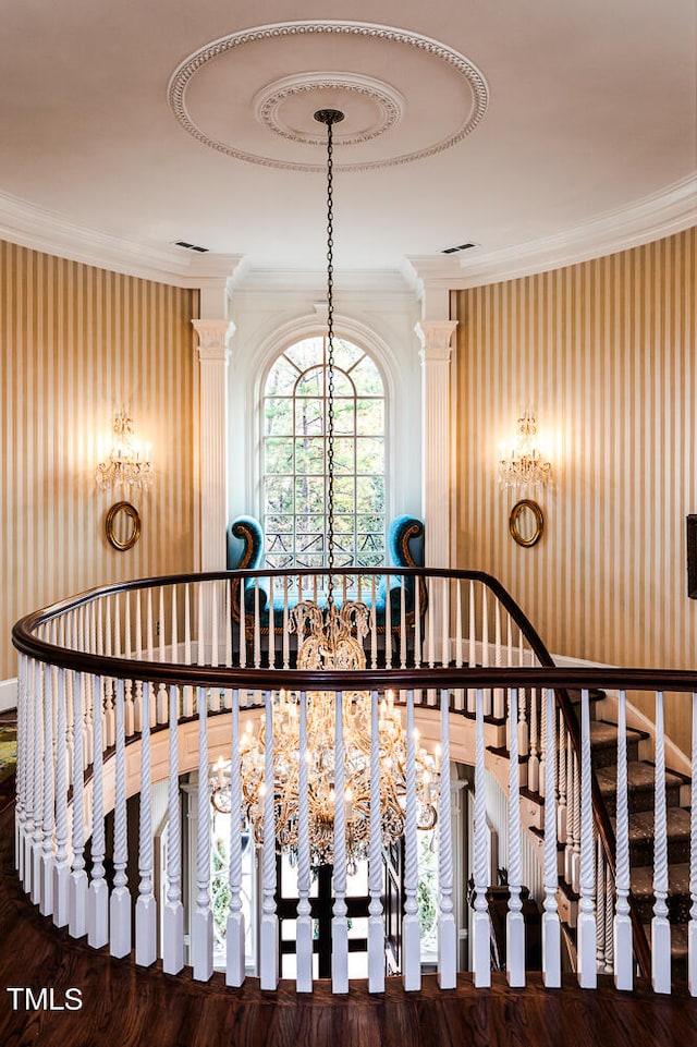 stairway featuring crown molding, dark hardwood / wood-style floors, and decorative columns