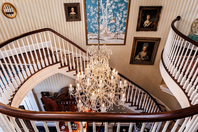 staircase featuring a towering ceiling and an inviting chandelier