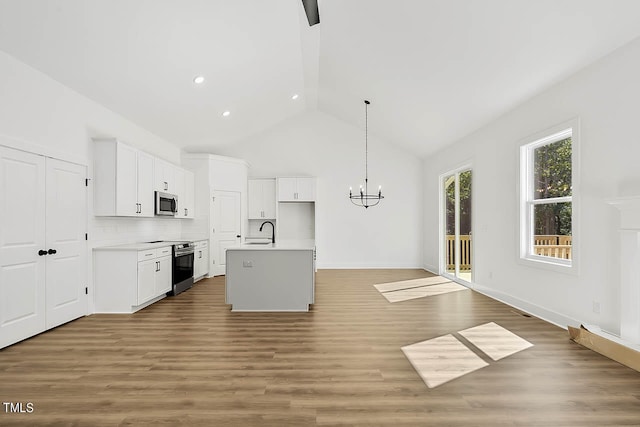 kitchen featuring an island with sink, white cabinets, hardwood / wood-style flooring, sink, and appliances with stainless steel finishes