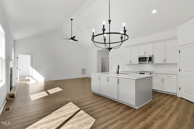 kitchen featuring an island with sink, white cabinets, and dark hardwood / wood-style floors