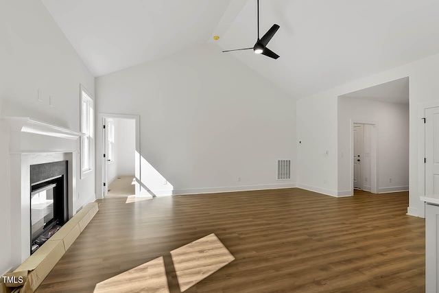 unfurnished living room with ceiling fan, dark wood-type flooring, and high vaulted ceiling