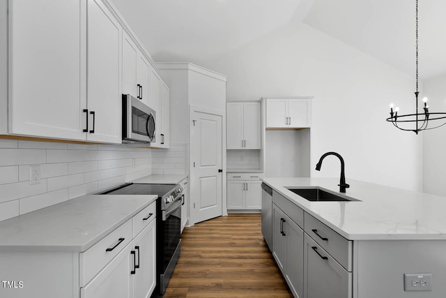 kitchen featuring light stone counters, pendant lighting, sink, white cabinetry, and appliances with stainless steel finishes