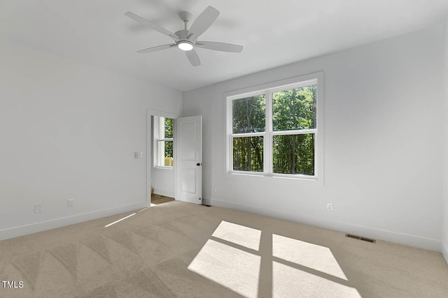 spare room featuring light carpet and ceiling fan