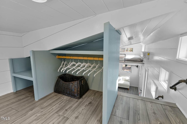 interior space featuring lofted ceiling and light hardwood / wood-style floors