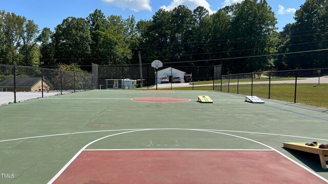 view of sport court with a yard