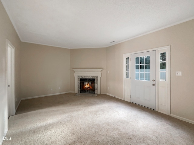 unfurnished living room with light carpet, a high end fireplace, and crown molding