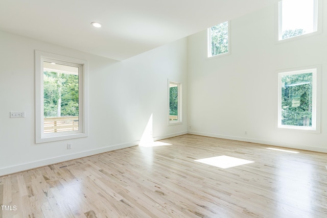 unfurnished room with light hardwood / wood-style floors and a high ceiling