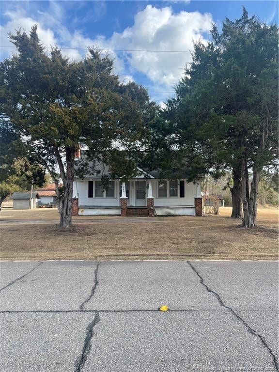 obstructed view of property with a front lawn