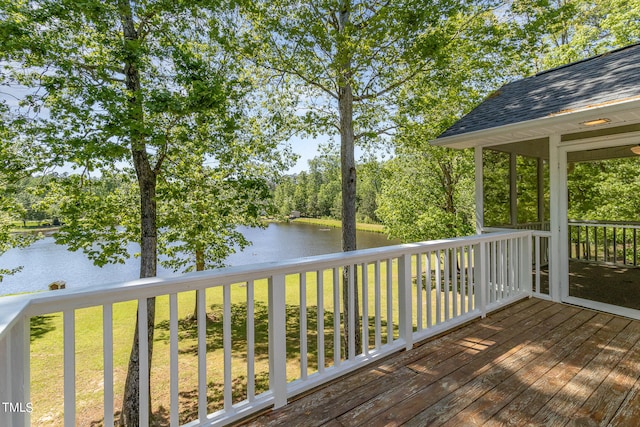 wooden terrace featuring a water view and a yard