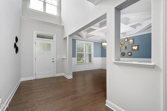 entrance foyer with ornamental molding, dark hardwood / wood-style floors, coffered ceiling, a chandelier, and beam ceiling