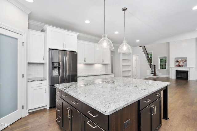 kitchen with dark wood-type flooring, pendant lighting, stainless steel fridge, tasteful backsplash, and white cabinetry