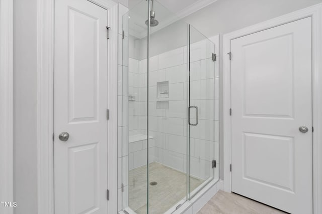 bathroom with ornamental molding and walk in shower