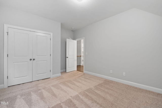 unfurnished bedroom with a closet and light colored carpet