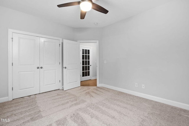 unfurnished bedroom featuring a closet, ceiling fan, and light colored carpet