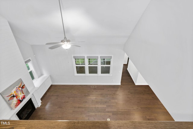 unfurnished living room with dark wood-type flooring and ceiling fan