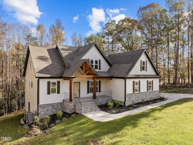 143 Hook Dr Lot 23, Fuquay Varina, NC 27526 - view of front of house with stone siding, a porch, a front lawn, central air condition unit, and roof with shingles