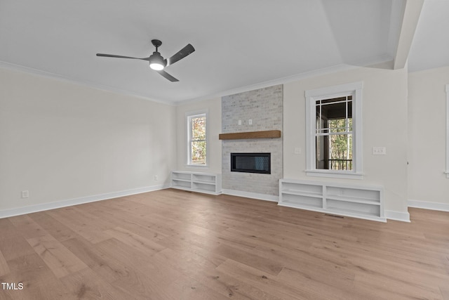 unfurnished living room with crown molding, ceiling fan, a fireplace, and light hardwood / wood-style floors