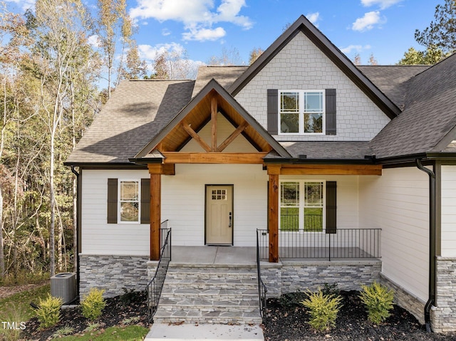 143 Hook Dr Lot 23, Fuquay Varina, NC 27526 - view of front of house featuring covered porch, roof with shingles, and central air condition unit