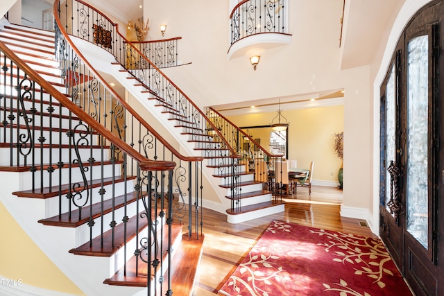 entryway featuring french doors, crown molding, and hardwood / wood-style floors