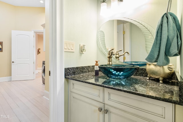 bathroom featuring vanity, hardwood / wood-style flooring, and washer / clothes dryer