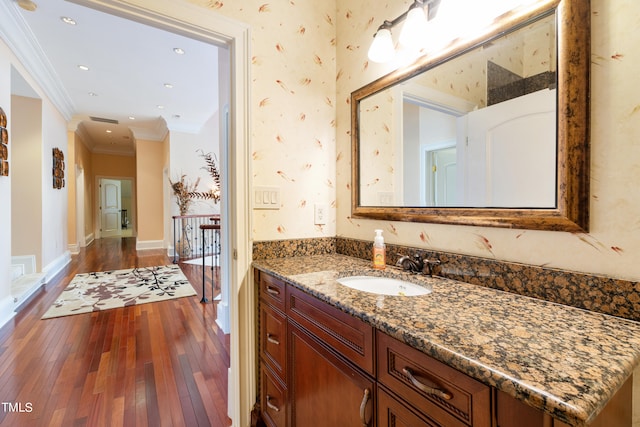 bathroom featuring vanity, ornamental molding, and hardwood / wood-style floors