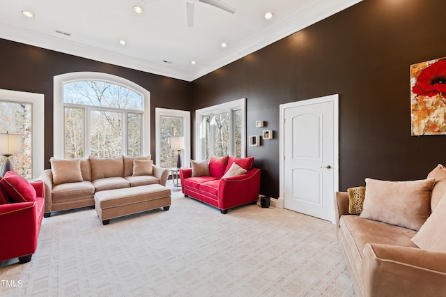 carpeted living room featuring ornamental molding and ceiling fan