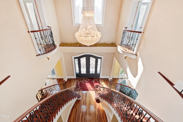 foyer entrance featuring hardwood / wood-style floors, a notable chandelier, french doors, and plenty of natural light