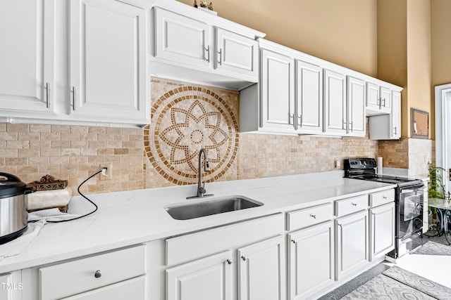 kitchen with sink, white cabinetry, electric range, and decorative backsplash