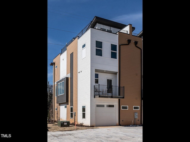 view of front of home featuring an attached garage and a balcony