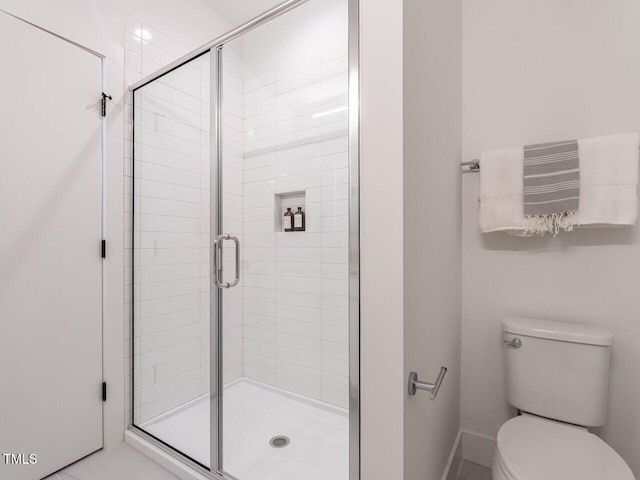 bathroom featuring a stall shower and toilet