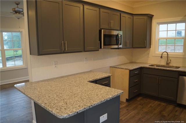 kitchen featuring a sink, light stone counters, tasteful backsplash, and stainless steel appliances