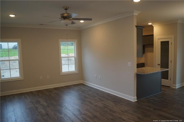 empty room featuring baseboards, dark wood-type flooring, ceiling fan, and ornamental molding