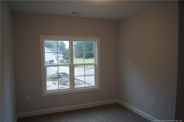 spare room with visible vents, baseboards, and carpet floors